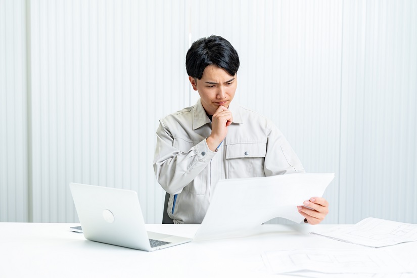 作業着を着た男性　険しい表情