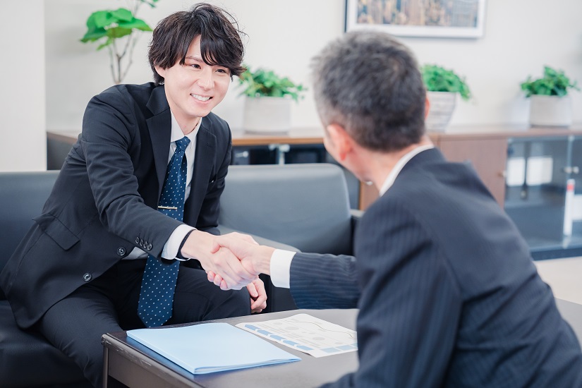 B2B商談で握手を交わすビジネスマン