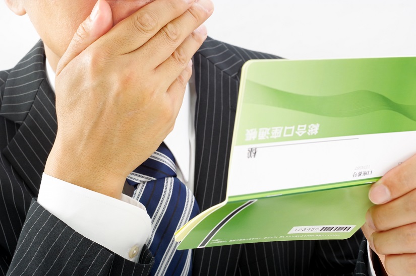 通帳を見て驚くビジネスマン