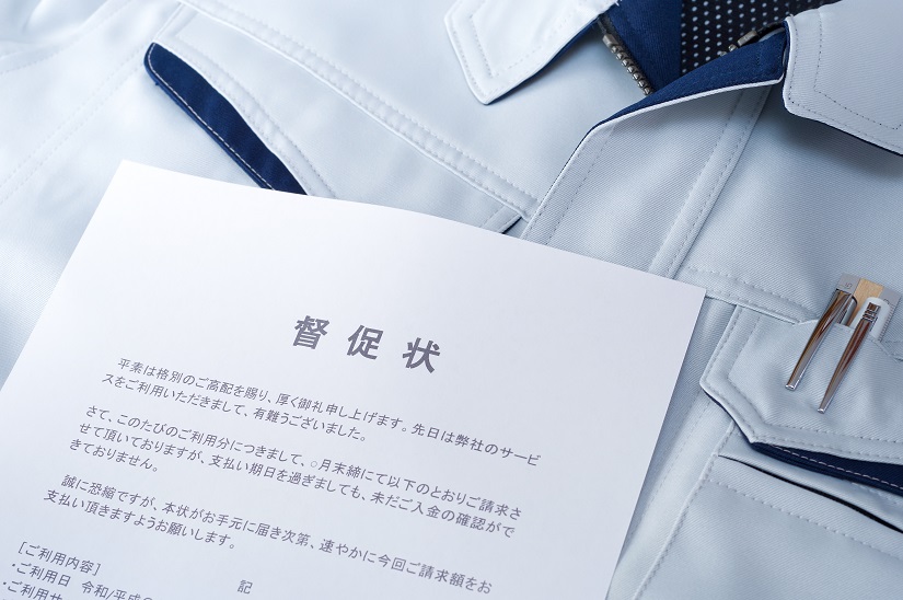 作業服の上に置かれた督促状