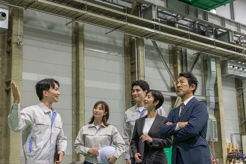 訪問者に工場を案内する作業員