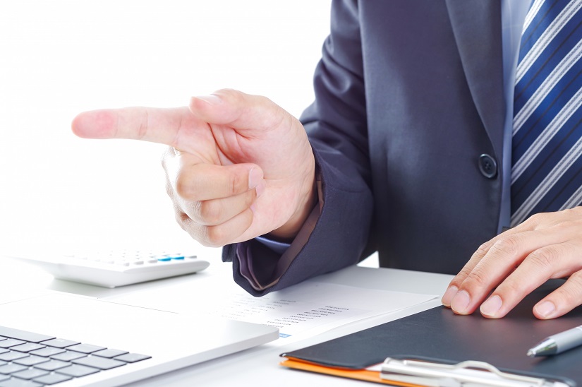 パソコンの前で指差しする男性