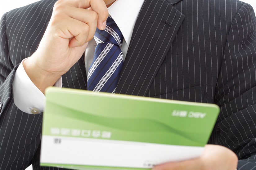 通帳を確認するビジネスマン