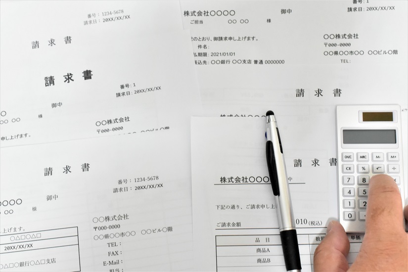 複数の請求書と電卓