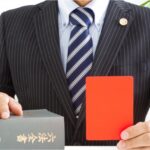 レッドカードを見せる弁護士