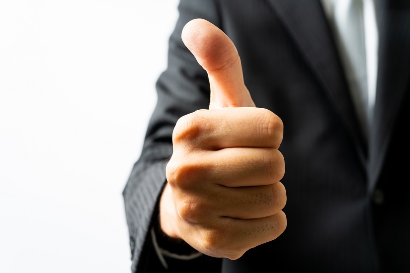 グッドサインをするスーツ姿の男性