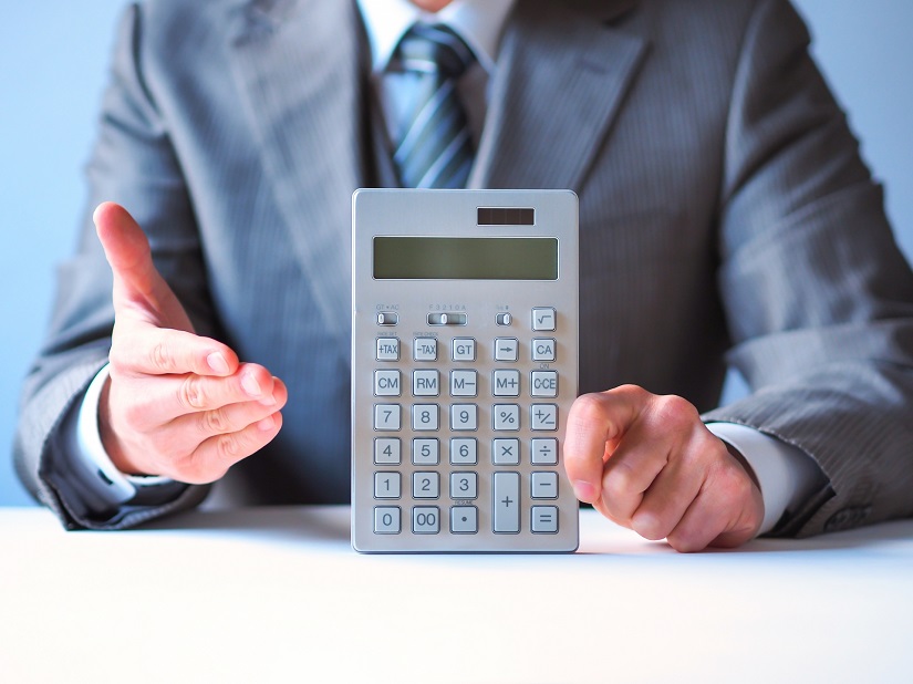 電卓　数字を見せるビジネスマン　